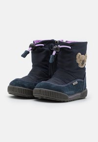 Marinblå vinterstövlar med ovandel i textil, gummisula, dragkedjestängning, lila detaljer och ett björnpatch på sidan. Mjuk foder synlig.