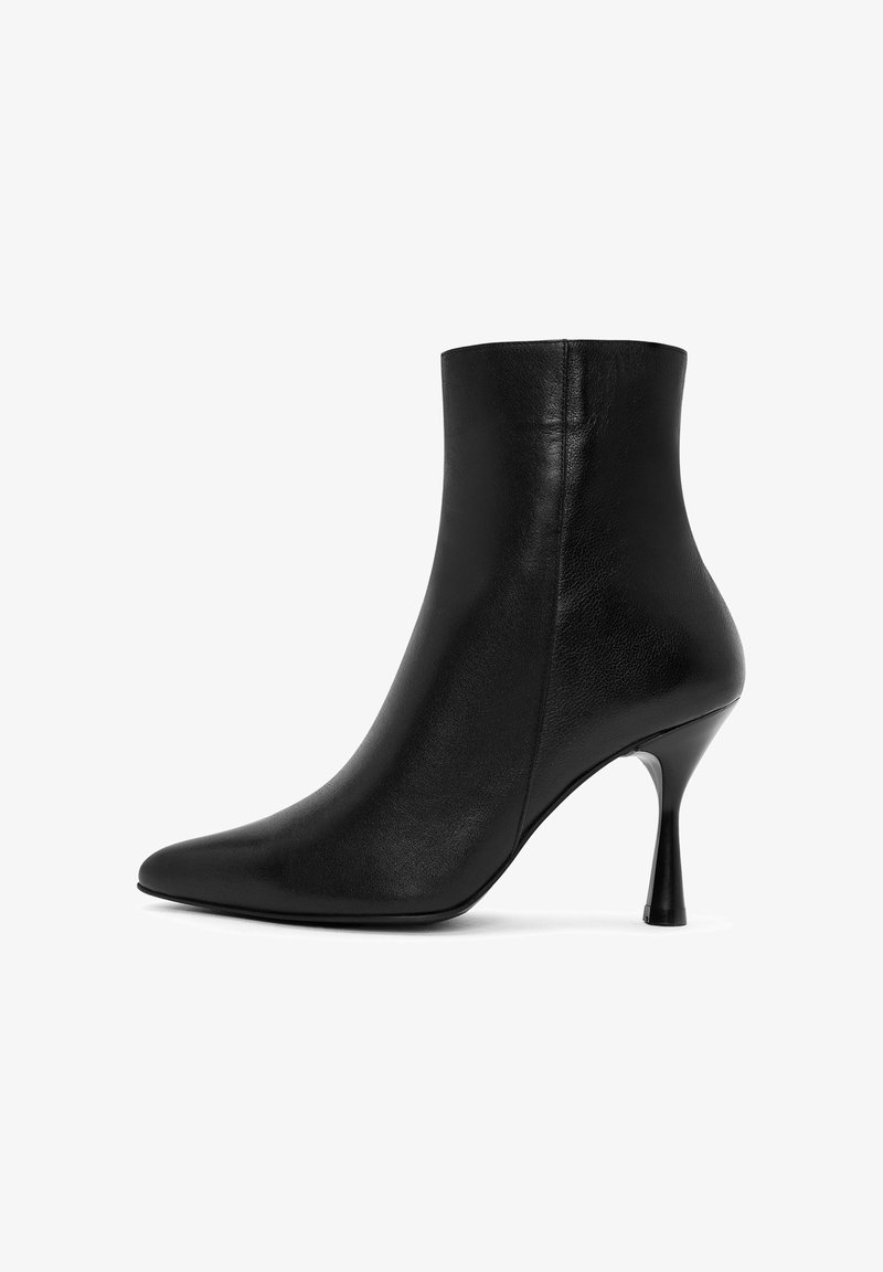 Bottillon en cuir noir avec un bout pointu et un talon aiguille, présentant une finition lisse et un design minimaliste.