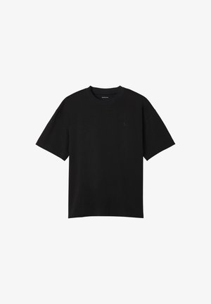 Czarna koszulka z krótkim rękawem i okrągłym dekoltem, z małym, subtelnym logo „CK” na lewej piersi, gładki wzór i regularny krój.