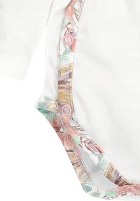 Biały body z długim rękawem ozdobione wiosennym wzorem w pastelowych kolorach. Posiada zapięcia na napy w różowym kolorze wzdłuż krawędzi. Wykonane z miękkiego materiału bawełnianego.