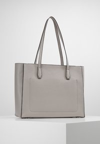 Borsa tote in pelle grigia con due manici, forma strutturata, cuciture a contrasto e una tasca frontale unica. Texture liscia.