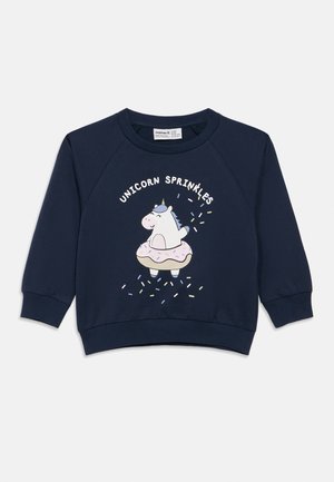 Marineblå barnegenser med en smilende enhjørning inni en rosa glasert doughnut og teksten "Unicorn Sprinkles" over.