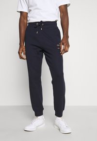 Navyblaue Jogginghosen aus Baumwollmischung, mit elastischem Bund und Kordelzug, gerippten Bündchen und goldfarbener Logo-Akzent am Oberschenkel.