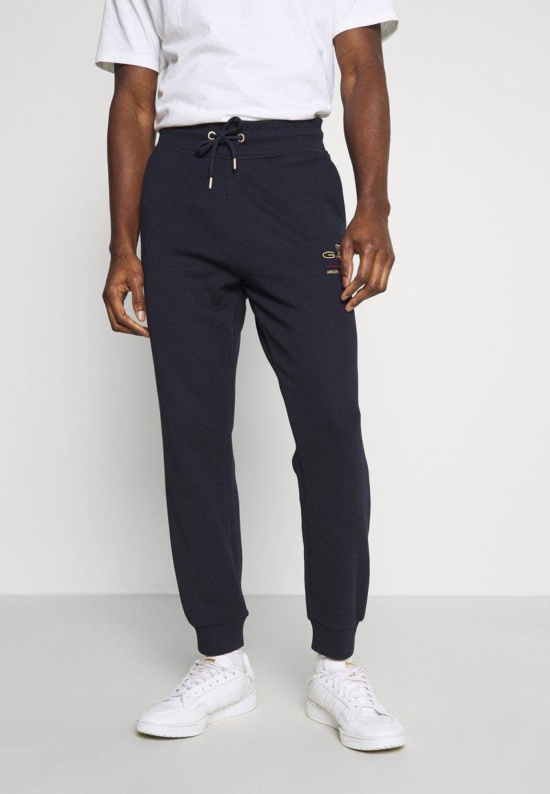 Navyblaue Jogginghosen aus Baumwollmischung, mit elastischem Bund und Kordelzug, gerippten Bündchen und goldfarbener Logo-Akzent am Oberschenkel.