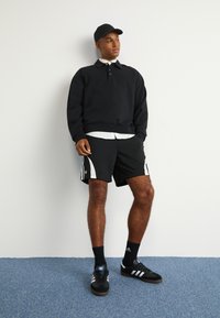 adidas Originals ADIDAS NTS RADIO ALLOVER PRINTED SUPERSTAR TRACK PANTS - Teplákové kalhoty - black