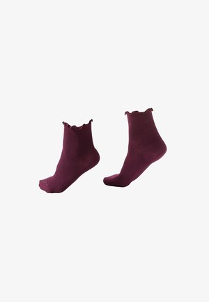 Paire de chaussettes bordeaux côtelées arrivant à la cheville avec des bords froncés, présentées comme si elles étaient portées aux pieds sur un fond blanc.
