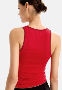 Czerwona, dopasowana bluzka bez rękawów z okrągłym dekoltem i kontrastującym ciemnym wykończeniem. Gładka tekstura i prosty design.