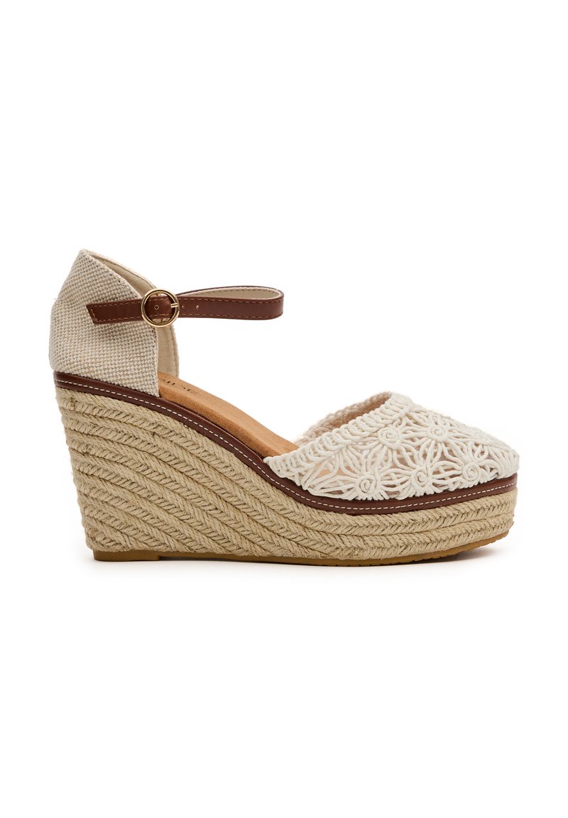 Zapato de cuña con punta cerrada, parte superior de tela bordada beige, correa marrón en el tobillo y plataforma de yute trenzado.