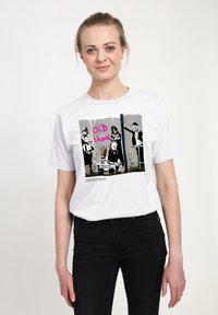 Biała bawełniana koszulka z graficznym nadrukiem w biało-czarnym wzorze oraz jaskraworóżowym napisem "OLD skool", przedstawiająca sztukę miejską.