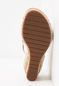 Semelle d'une sandale compensée beige tressée avec une semelle en caoutchouc marron indiquant la marque Gabor et la pointure 4 1/2.