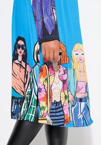 Bright blue dress featuring illustrated women in various outfits, with floral and striped patterns, and detailed accessories like sunglasses.