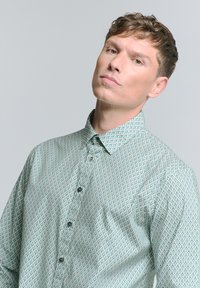 Lichtgroen shirt met patroon, voorzien van een ruitontwerp, met een button-down kraag en zwarte knopen. De stof lijkt glad en licht van gewicht te zijn.