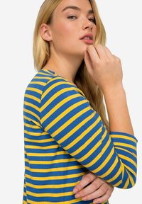 Camicia a righe in tessuto di cotone blu e giallo, design aderente, maniche 3/4, con scollatura rotonda e consistenza morbida.