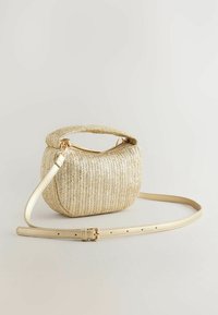 Goldfarbene Handtasche aus gewebtem Material mit einem kurzen Griff und einem langen, verstellbaren Trageriemen, vor einem schlichten hellen Hintergrund präsentiert.