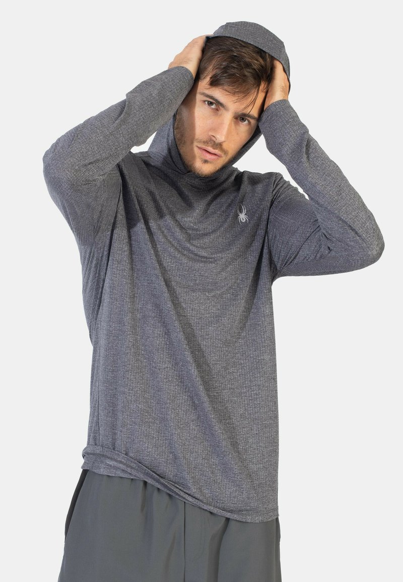 Grå, langærmet hættejakke lavet af tekstureret stof med en snøret hætte og et subtilt logo på brystet. Casual fit, blød og let.