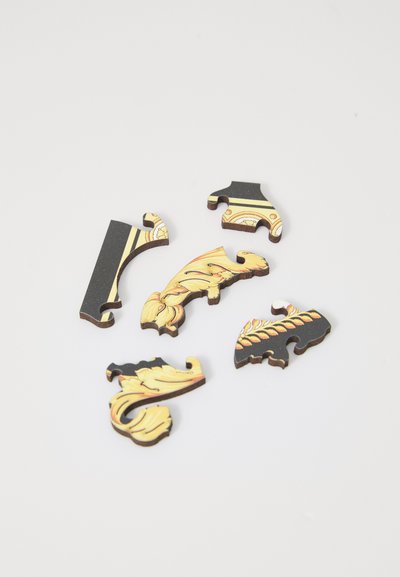 Decorative wooden puzzle pieces in shades of black and gold, featuring floral patterns and intricate designs with smooth edges.