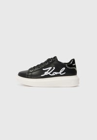 Black leather sneaker featuring white embroidered "Karl" detail, round toe, lace-up design, and a thick white sole with textured accents.