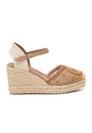 Sandalia de cuña tipo esparto con suela de yute tejido, tiras beige en el tobillo con hebilla y cubierta decorativa de crochet marrón claro en los dedos.