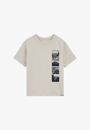 Bež kratka majica s kratkimi rokavi z navpičnimi črno-belimi naravnimi potiski in napisom "Puerto Montaña" na levi strani prsnega koša.