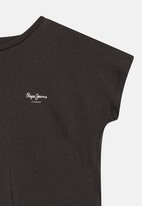 Czarnoszary, krótki rękaw, t-shirt wykonany z bawełny. Posiada białe logo "Pepe Jeans London" na klatce piersiowej. Gładka tekstura i luźny krój.