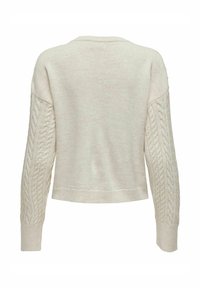 Sweter w kolorze kremowym z detalami w warkocze na rękawach, okrągłym dekoltem i ściągaczami. Miękka tekstura, krótka długość oraz prosty design.