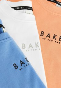 Trys marškiniai: mėlyni, balti ir oranžiniai, pagaminti iš švelnaus medvilnės. Kiekvienuose yra užrašas "BAKER by TED BAKER" kontrastingomis spalvomis priekyje.