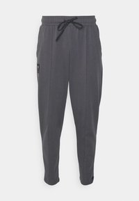 Graue Jogger-Hosen mit einem elastischen Bund, verstellbarem Kordelzug, seitlichen Taschen und einem dezenten Logo-Patch am linken Bein. Glatte Stofftextur.