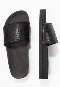 Black slide sandals with a textured leather strap and a padded footbed. Features a flat sole with a zigzag edge for grip and style.