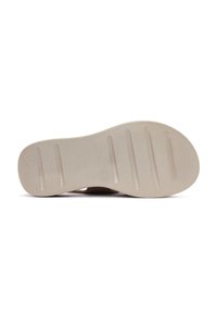 Suola beige con una texture liscia e numerose scanalature orizzontali per trazione. Forma arrotondata con un arco sottile.