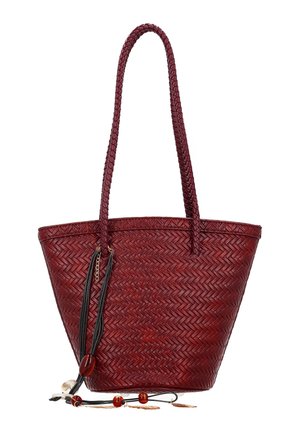 Czerwona pleciona skórzana torba typu tote z plecionymi uchwytami oraz czarnymi frędzlami ozdobionymi koralikami i muszlami wiszącymi z jednego uchwytu.