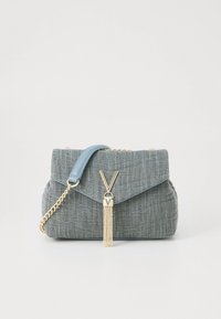 Bolso texturizado gris con solapa de cuero azul, correa de cadena dorada y cierre dorado en forma de V con detalle de borla sobre fondo blanco.