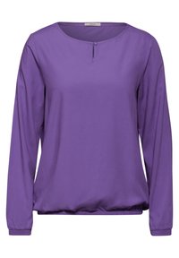 Haut long à manches violettes en tissu lisse, avec un col rond et un petit détail en forme de trou de serrure, ainsi qu'un ourlet et des poignets élastiques.