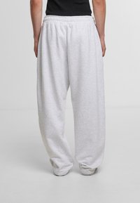 Gray sweatpants with an elastic waistband, featuring a loose fit and ribbed ankle cuffs, made from soft, textured cotton material.