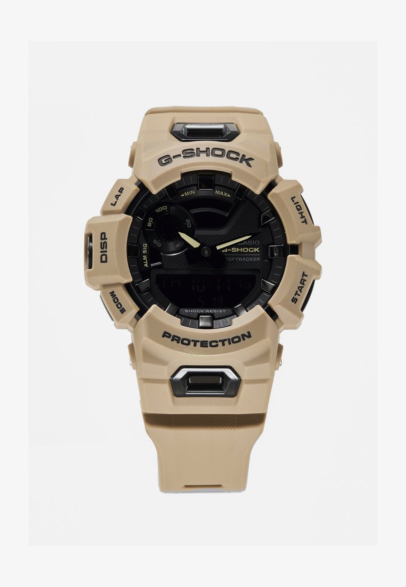 Tan G-SHOCK Uhr mit schwarzem Zifferblatt, ausgestattet mit einem Harzgehäuse, Digitalanzeige, großen Tasten und beschriftet mit "PROTECTION" und "LIGHT."
