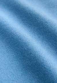 Weicher, strukturierter Stoff in Hellblau, mit einer glatten, leicht flauschigen Oberfläche und subtilen Webartvariationen.