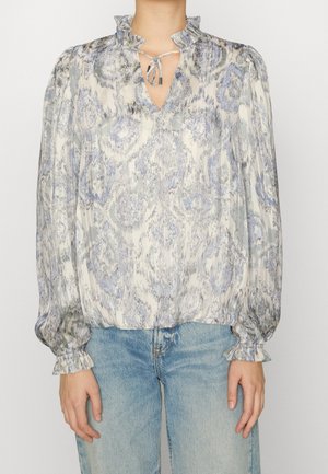 Vzdušná halenka ve světle modré a krémové barvě s květinovým vzorem, volánkovým výstřihem, výřezem na klíč a elastickými manžetami. Kombinováno se světlými džínami.