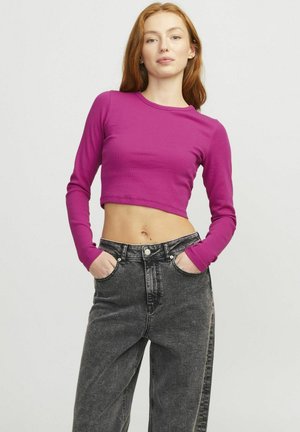 Fitted, lange mouwen crop top in levendig fuchsia, gemaakt van ribbelstof. Gecombineerd met high-waisted, loszittende zwarte denim jeans.