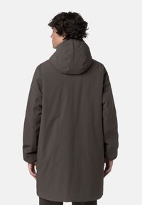 Parka lunga di un marrone scuro, con cappuccio, texture liscia e tasche a pattina. Presenta una vestibilità comoda e un design pulito e minimalista.