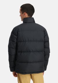 Daunenjacke in Dunkelgrau, mit hohem Kragen, gestepptem Design und elastischen Bündchen. Leichtes Material mit glatter Textur.
