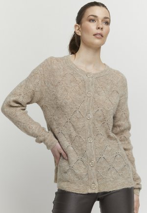 Beige stickad cardigan med diamantspetsmönster, rundad halsringning och sex knappar fram. Lång ärm och avslappnad passform.