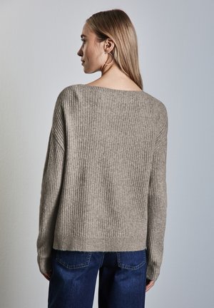 Maglione rigato beige chiaro con scollo ampio e maniche lunghe, caratterizzato da una vestibilità comoda e una consistenza morbida, abbinato a jeans blu scuro.