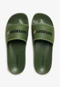 Groene schuifslippers met een gladde synthetische bovenkant. Voorzien van een brede band met "SUPERDRY" branding en een geprofileerde voetbed voor grip.