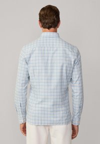 Blue and white checked shirt with long sleeves, button cuffs, a pointed collar, and a curved hem, made from lightweight cotton fabric.