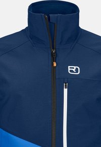 Blaue Jacke mit hohem Kragen, schwarzem Reißverschluss und weißen Akzenten. Enthält eine Reißverschlusstasche und ein Logo auf der Brust. Strukturiertes Stoffmaterial.