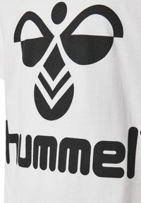 Witte katoenen t-shirt met een grote zwarte afbeelding van een gestileerde bij en het woord "hummel" in vette zwarte letters.