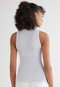 Grijze geribbelde tanktop met mouwloze ontwerp, hoge halslijn en gestructureerde stof, getailleerde silhouet. Geen extra versieringen of patronen.