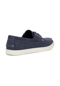 Navy blue leather sneaker with white stitching, a rounded toe, and a low rubber sole. Features lace-up closure and side eyelets.