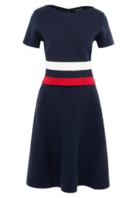 Marinblå klänning med korta ärmar, med vita och röda horisontella ränder vid midjan. A-linjeformad silhuett och dragkedja bak.