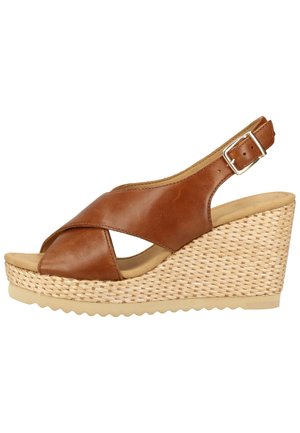 Sandale à wedge en cuir marron avec design à brides croisées, texture en jute tissé sur le talon, bride de cheville ajustable et semelle en caoutchouc.