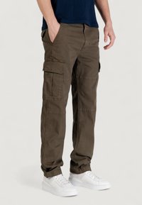Pantalon cargo vert olive, fabriqué en tissu durable, avec plusieurs poches latérales et une coupe ample. Accentué par un design à jambe droite.